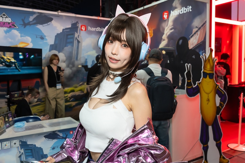 「東京ゲームショウ2025」の美人コスプレイヤー＆コンパニオン特集｜胸開きニット衣装がセクシーなコンパニオンが『Grand Outlaws』を大展開する「GRAND OUTLAWS」ブースでお出迎え